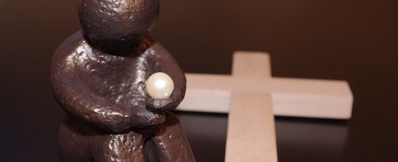 Frauenstunde sitzende Skulptur vor Kreuz